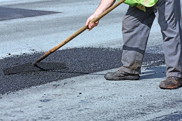 Patched pothole in a commercial asphalt parking lot